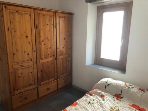 - une chambre avec des placards en bois, un lit et une fenêtre dans l'établissement Apt de charme sur la Marina de Bonifacio, à Bonifacio