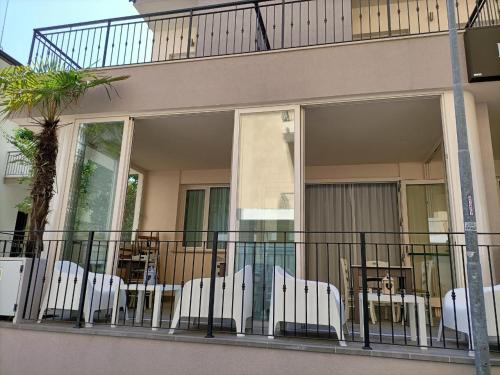 a balcony with chairs and tables on a building at Hotel Bed and Book in Rimini