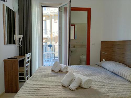 a bedroom with a bed with towels on it at Hotel Bed and Book in Rimini