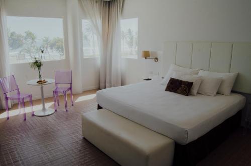 埃尔阿瓜Agua Dorada Beach Hotel By Lidotel的一间卧室，配有一张床、一张桌子和几把椅子