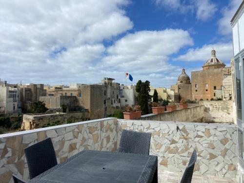 een tafel en stoelen op een balkon met uitzicht op de stad bij Sqaq Numru 1 Accomodation in Rabat