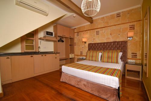 a bedroom with a large bed and a kitchen at Swim-Up Garden Flat with near Hadrian's Gate in Antalya