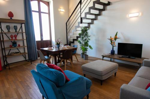 a living room with a table and a blue couch at Le Maree Deluxe Apartment by Dimore Trinacria in Siracusa
