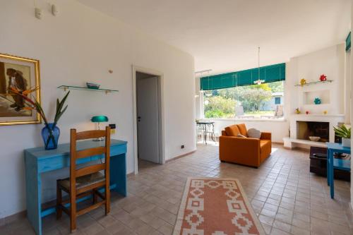 - un salon avec un bureau bleu et un canapé dans l'établissement Villa Kore, Capo Vaticano, à Capo Vaticano