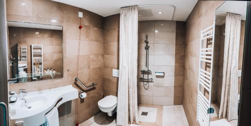a bathroom with a toilet and a sink and a shower at Appart One Uzès in Uzès