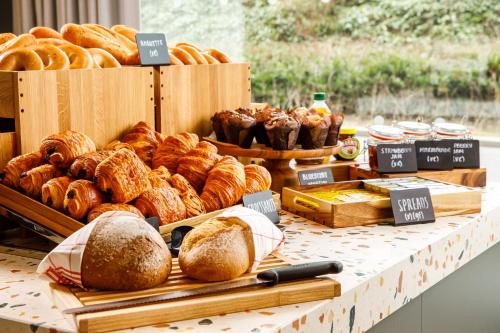 a table topped with lots of different types of bread at Holiday Inn Manchester Airport T2 by IHG in Hale