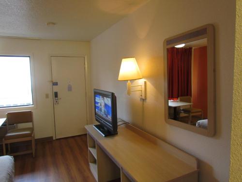 a hotel room with a television on a desk with a mirror at Motel 6-Vancouver, WA in Vancouver