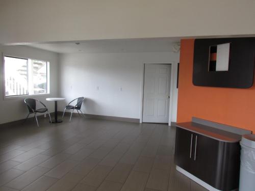 an empty room with chairs and a table and a door at Motel 6-Vancouver, WA in Vancouver