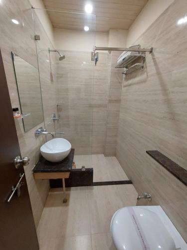 a bathroom with a sink and a toilet and a shower at Hotel Vrinda in Maihar