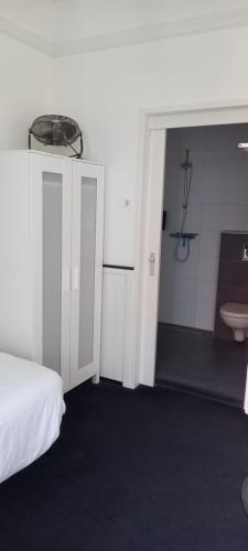 a bedroom with a bed and a bathroom with a sink at Stad & Strandhotel Elisabeth in Vlissingen