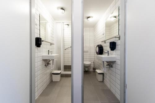 a bathroom with two sinks and two toilets at Adagio Hostel Basilica in Budapest
