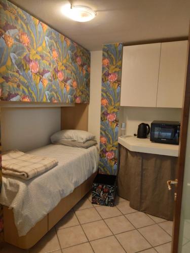 ein kleines Schlafzimmer mit einem Bett und einem Gemälde an der Wand in der Unterkunft Sotto Sotto in Viareggio
