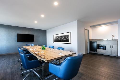 a conference room with a large wooden table and blue chairs at The Simon Hotel Sydney in Sydney