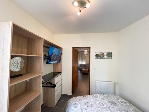 - une chambre avec un lit et une télévision à écran plat dans l'établissement Résidence Investar appartement 3, à Montluçon