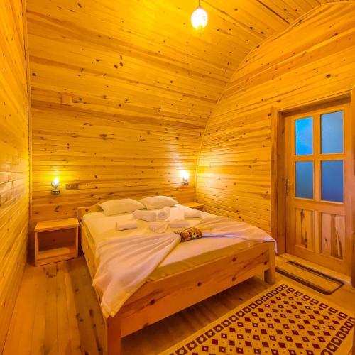 um quarto com uma cama num quarto de madeira em Kazdağları Sağlıklı Yaşam Köyü em Edremit