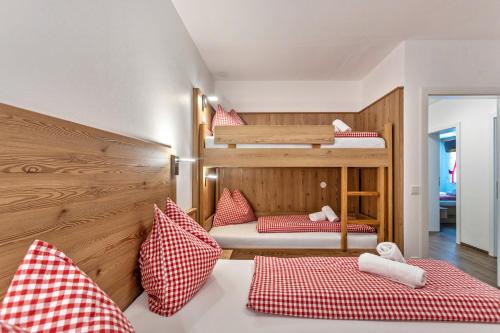 Habitación con 2 literas y almohadas rojas y blancas. en Apartment mit Blick auf die Berge, en Rettenstein