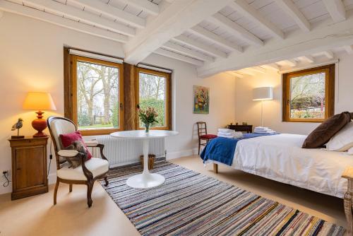 sypialnia z łóżkiem, stołem i krzesłami w obiekcie Maison "Le Pressoir" avec Grand Jardin w mieście Biéville-en-Auge