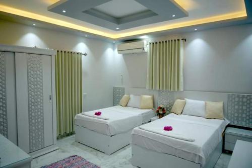- une chambre avec 2 lits avec des fleurs roses dans l'établissement Arbian Valla, à Dahab