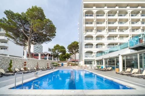 a swimming pool in front of a building at Seramar Hotel Comodoro Playa in Palmanova