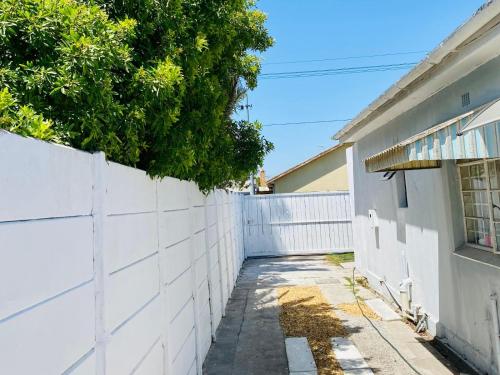 a white fence next to a house at Le Lieu Accommodation in Cape Town