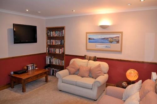 a living room with a chair and a tv at Lochview House in Fort William