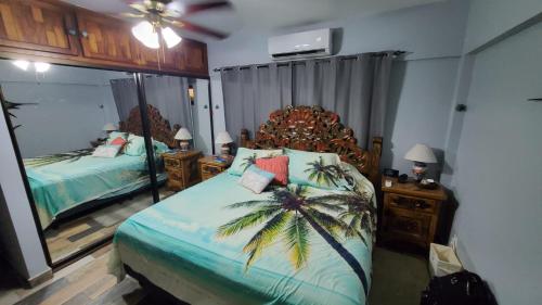 a bedroom with a bed with a palm tree on it at Marina Sol in Cabo San Lucas