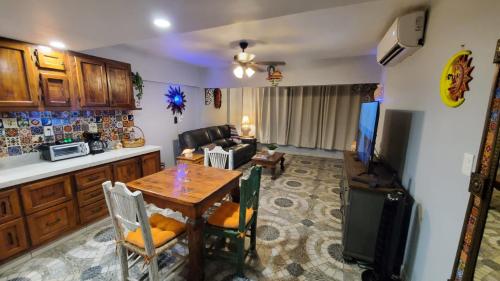 uma cozinha e sala de estar com uma mesa e uma televisão em Marina Sol em Cabo San Lucas