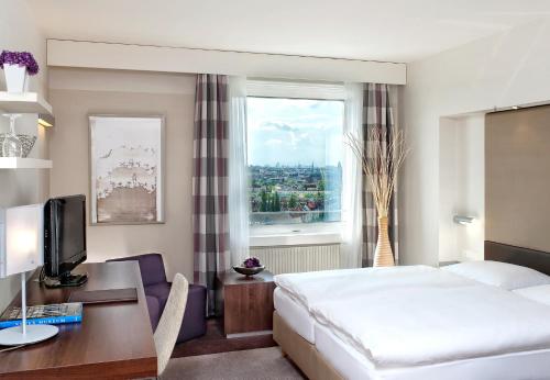 pokój hotelowy z łóżkiem i oknem w obiekcie Estrel Berlin w Berlinie
