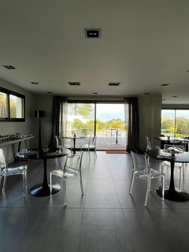 a restaurant with tables and chairs and a large window at Lafitenia Resort in Saint-Jean-de-Luz