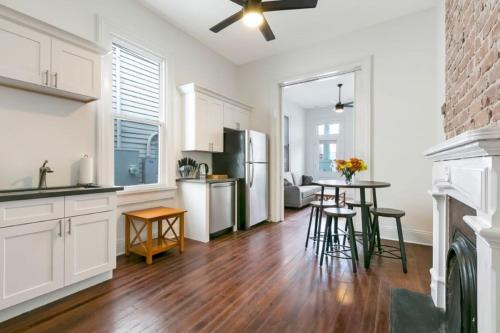 Una cocina con gabinetes blancos y una mesa con sillas. en Luxury 4BR in Uptown NOLA, en Nueva Orleans