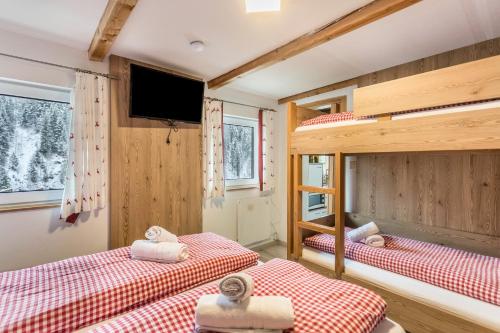 a room with two bunk beds and a flat screen tv at Chalet Berger in Sankt Johann im Pongau