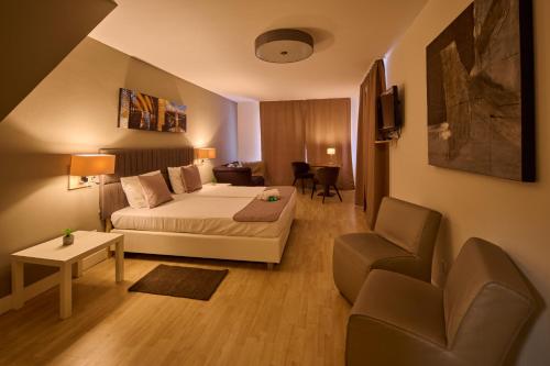 シュマレンベルクにあるParkhotel Schmallenbergのベッド、ソファ、椅子が備わるホテルルームです。