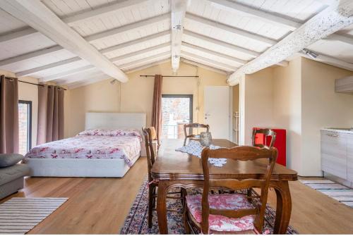 1 dormitorio con 1 cama, mesa y sillas en Alloggio incantevole con piscina, en Vinci
