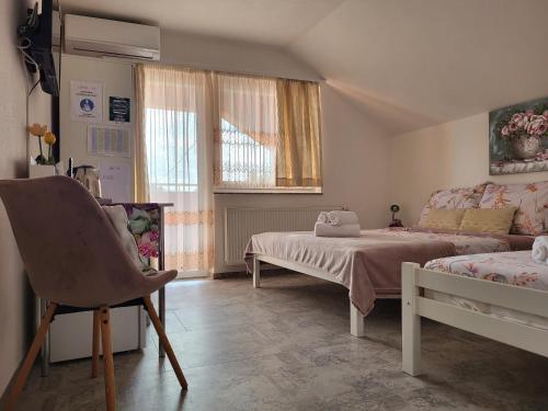 a bedroom with a bed and a couch and a window at Rooms Sapina in Korenica