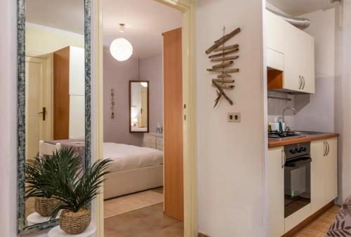 ein Zimmer mit einer Küche und ein Schlafzimmer mit einem Bett in der Unterkunft Trilocale a 150 metri Spiaggia Alghero in Alghero