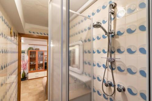 a bathroom with a shower with blue circles on the wall at Trilocale a 150 metri Spiaggia Alghero in Alghero