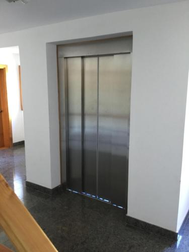 una gran puerta de metal en una habitación con paredes blancas en Departamento victoria en San Martín de los Andes