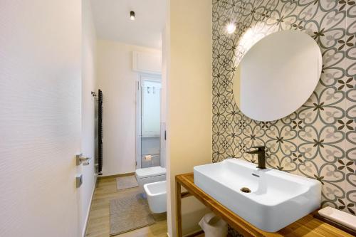 Un baño con un lavabo blanco y un espejo. en Victoria Apartments Family, en Diano Marina