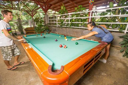 a man and a woman playing a game of pool at Hotel Arenal Country Inn in Fortuna