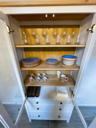 a cupboard with plates and dishes on it at NORD MILANO LUXURY APARTMENTS in Bresso