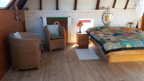 een slaapkamer met een bed en een stoel bij De Geheime Tuin - Uitzicht in Epe