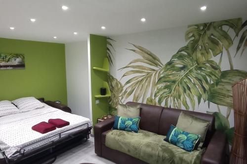1 dormitorio con 1 cama y 1 sofá en F1 idéalement situé en RDC, en Raon-lʼÉtape