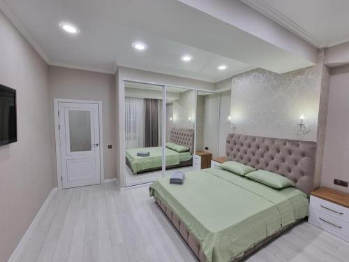 キシナウにあるComfortable Luxury Apartments in Centerの広いベッドルーム(ベッド2台、鏡付)