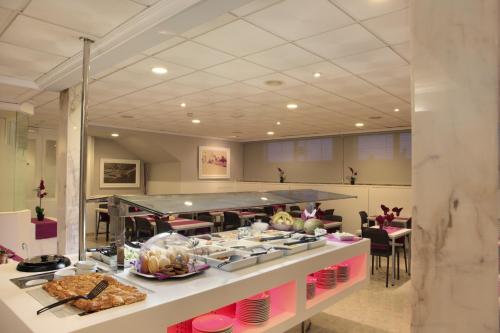a buffet line with food in a restaurant at Hotel Bilbaino in Benidorm