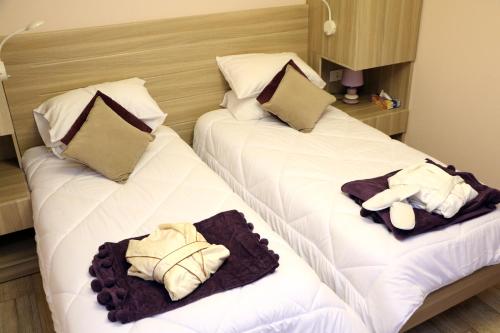 2 Betten in einem Hotelzimmer mit Handtüchern darauf in der Unterkunft HOtello guest suites in Jounieh