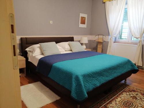 - une chambre avec un lit et une couverture bleue dans l'établissement Guesthouse Juric, à Skradin