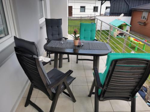 een patio tafel en stoelen op een balkon bij Ferienwohnung Hertreiter in Dingolfing 110qm in Dingolfing