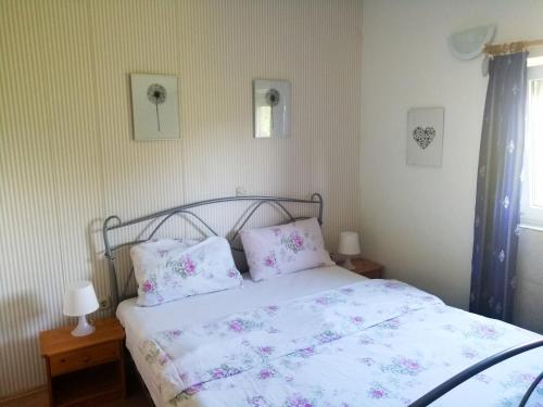 een slaapkamer met een bed met roze lakens en kussens bij One bedroom appartement at Zaton 200 m away from the beach with furnished garden and wifi in Zaton