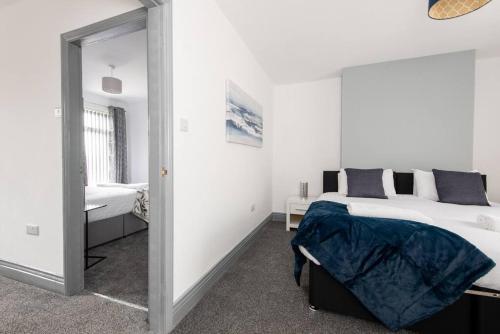 a white bedroom with a bed and a mirror at 25 Station in Ushaw Moor