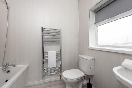 a white bathroom with a toilet and a sink at 25 Station in Ushaw Moor